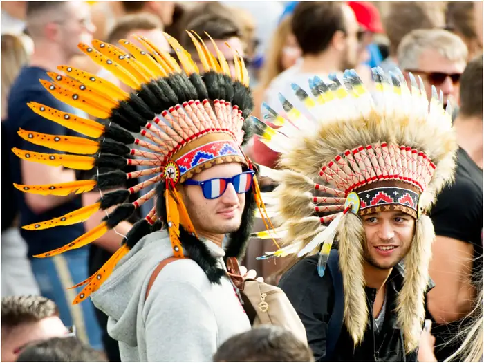is it offensive to wear the Yin and Yang symbol? Seeing these two men wearing Native American headdresses is kind of offensive.  Just kind of. 